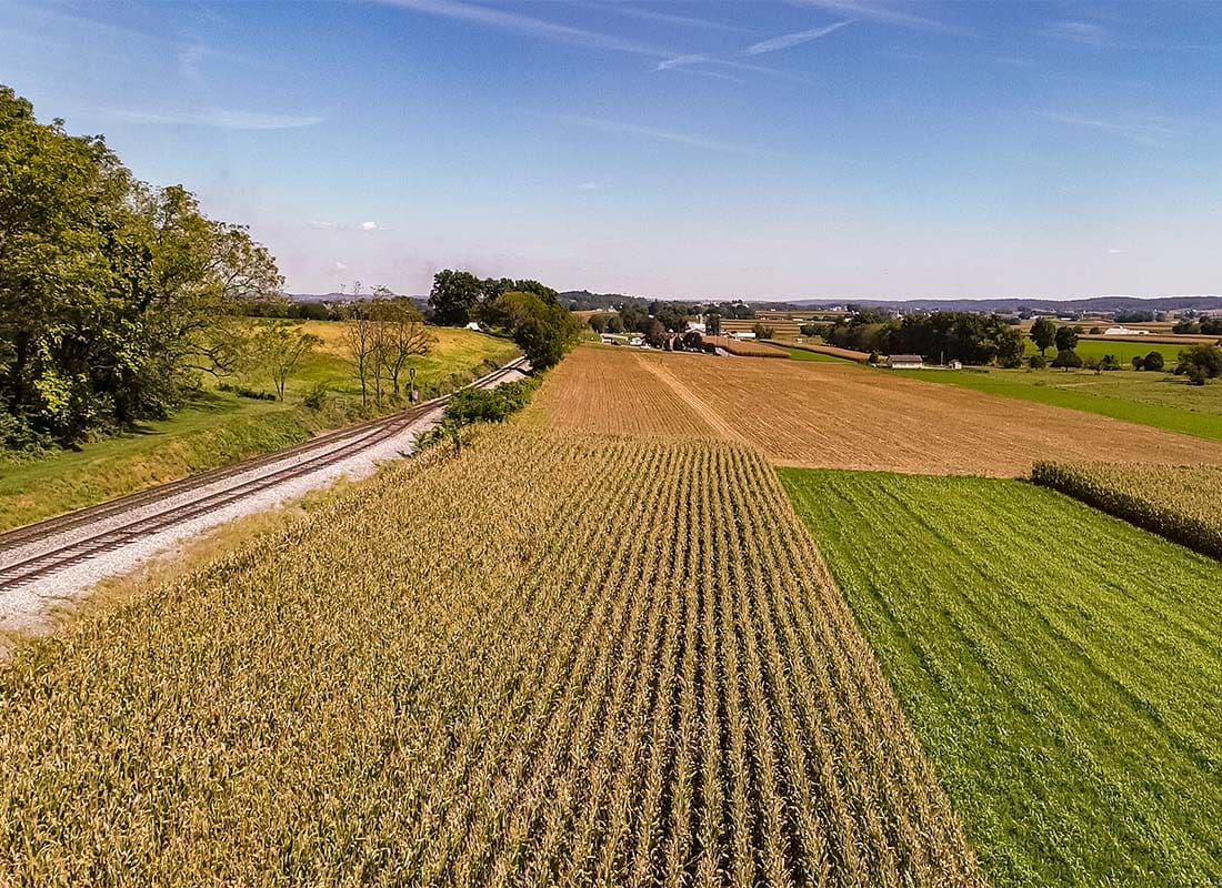 Deshler, OH - View of Farm FIelds Next to a Railroad Track Surrounded by Green Foliage in Deshler Ohio on a Sunny Day